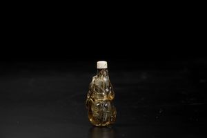 Snuff bottle scolpita in cristallo di rocca con figure di scimmiette ed elementi vegetali a rilievo, Cina, Dinastia Qing, XIX secolo  - Asta Arte Orientale - Associazione Nazionale - Case d'Asta italiane