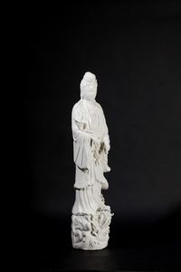 Figura in porcellana Blanc de Chine raffigurante Guanyin eretta su con vasetto, ramo fiorito e drago sulla base, Cina, inizi XX secolo  - Asta Arte Orientale - Associazione Nazionale - Case d'Asta italiane