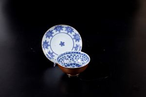 Lotto composto da coppa e piattino in porcellana bianca e blu con decori floreali, Cina, Dinastia Qing, XVII-XVIII secolo  - Asta Arte Orientale - Associazione Nazionale - Case d'Asta italiane