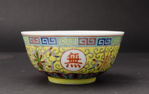 Piccola ciotola in porcellana a smalti policromi con simboli taoisti, fiori di loto e motivo a greca su fondo giallo, Cina, XX secolo  - Asta Arte Orientale - Associazione Nazionale - Case d'Asta italiane