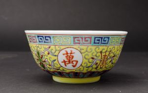 Piccola ciotola in porcellana a smalti policromi con simboli taoisti, fiori di loto e motivo a greca su fondo giallo, Cina, XX secolo  - Asta Arte Orientale - Associazione Nazionale - Case d'Asta italiane