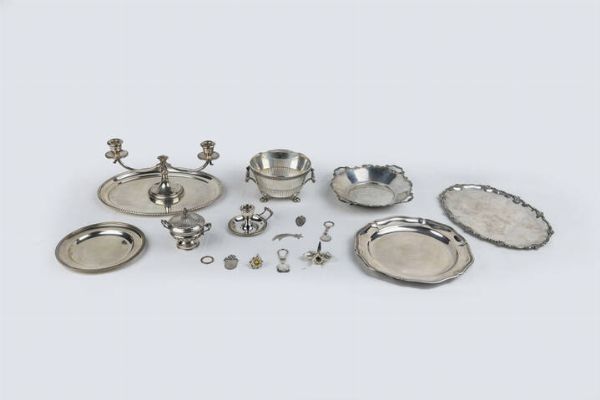 LOTTO DI DICIASSETTE OGGETTI IN ARGENTO : Peso gr 3513 9 -1 Candeliere a due luci. Peso gr 429 9 -1 bugia. Peso gr106 4 -1 sechiello con zampe leonine. Peso gr 604 4 -1 vassoio ovale. Peso gr 552 7 -1 zuccheriera. Peso gr 130 5 -1 alzata rotonda ocn piedini a volute. Peso gr 339 3 -1 piatto rotondo con bordo mosso. Peso gr 494 1 -1 piattino con decoro a palmette. Peso gr 248 1 -1 vassoio ovale con bordo mosso. Peso gr 494 5 - 5 oggetti vari: 3 segnalibro e due fiori in argento 925/1000. Peso gr 55 9 -3 portachiavi in argento 924/1000. Peso gr 58 1  - Asta  Dipinti, argenti e antiquariato - Associazione Nazionale - Case d'Asta italiane