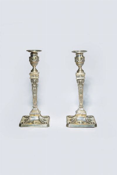 COPPIA DI CANDELIERI : H cm   30 Peso lordo gr 1276 2 e 1283 9 citt di Londra  1734-1735  argentiere non identificato. Corpo a colonna rastremata con profili sbalzati a ghirlande fiorite e teste di arieti.Parte superioria vaso con decori a festoni. Poggianti su basi quadrate e sbalzate con motivi di foglie e vasi  - Asta  Dipinti, argenti e antiquariato - Associazione Nazionale - Case d'Asta italiane