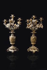 COPPIA DI CANDELIERI - H cm 62 in bronzo dorato (difetti) a cinque luci caduano  montate su gigli e foglie; parte centrale lavorata a  [..]