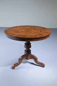 TAVOLO DA CENTRO - H. cm 75x90 in legno di noce; colonna centrale lavorata a rocchetto terminante con con tre piedi a volute. Piano  [..]