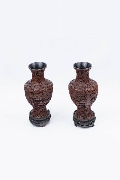 COPPIA DI VASI : Coppia di vasi in lacca rossa  rappresentanti paesaggio con figure e poggianti su basi in legno  Cina dinastia Qing XX  sec. H cm 23  - Asta Arte Orientale - Associazione Nazionale - Case d'Asta italiane