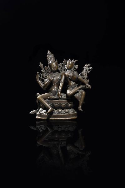 BUDDHA CON FIGURA FEMMINILE : Buddha con figura femminile in bronzo brunito  seduti su doppio fiore di loto  Tibet  XX sec. H cm 19 5x20x12  - Asta Arte Orientale - Associazione Nazionale - Case d'Asta italiane