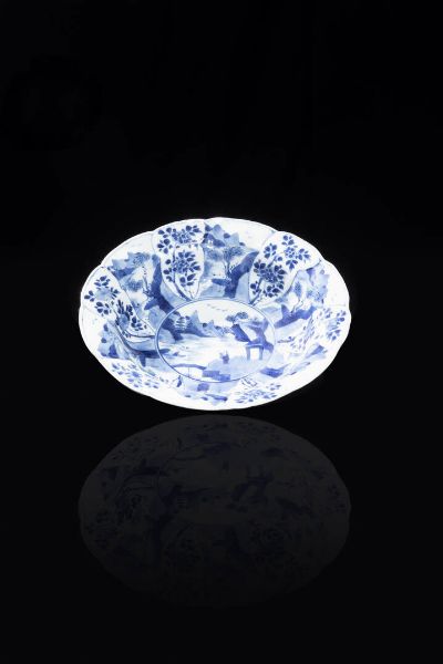 PIATTO : Piatto in porcellana bianco e blu raffigurante monaco entro paesaggio  Cina  dinastia Qing  XVIII sec. Diam cm 21 5  - Asta Arte Orientale - Associazione Nazionale - Case d'Asta italiane