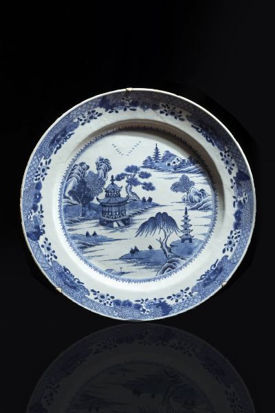 PIATTO : Piatto in porcellana bianco e blu con decori di pagode entro paesaggio  Cina  dinastia Qing  epoca Kangxi (1662-1722) Diam cm 45 5  - Asta Arte Orientale - Associazione Nazionale - Case d'Asta italiane