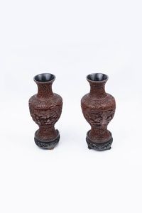 COPPIA DI VASI - Coppia di vasi in lacca rossa  rappresentanti paesaggio con figure e poggianti su basi in legno  Cina dinastia  [..]