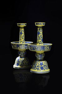 COPPIA DI CANDELIERI - Coppia di candelieri in porcellana gialla con decori di fiori nei toni del blu  Cina  XX sec. H cm 33x17