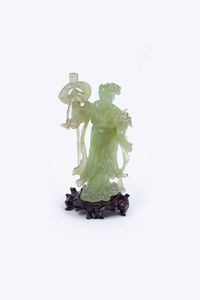 GUANYIN - Guanyin in giadeite raffigurante donna con attrezzi e fiori  poggiante su base in legno  Cina  Repubblica  XX  [..]