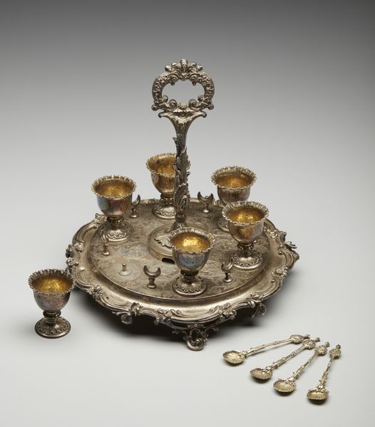 ARGENTIERE INGLESE DEL XIX SECOLO : Portauova in argento cesellato composto da 6 coppette e 4 cucchiaini, su vassoio circolare a decorazioni fitomorfe  - Asta Asta 395 | ARTE ANTICA E DEL XIX SECOLO Online - Associazione Nazionale - Case d'Asta italiane