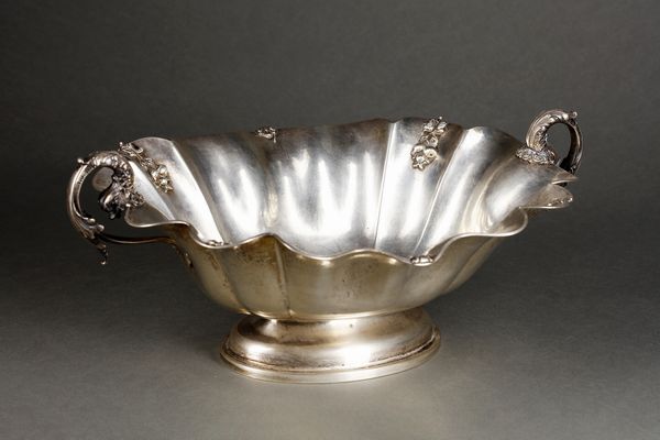 ARGENTIERE ITALIANO DEL XX SECOLO : Alzata centrotavola in argento con bordo mistilineo e decorazioni vegetali a rilievo, manici in forma di delfini, poggiante su base ovale  - Asta Asta 395 | ARTE ANTICA E DEL XIX SECOLO Online - Associazione Nazionale - Case d'Asta italiane