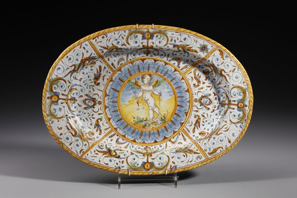 MANIFATTURA DI DERUTA : Piatto ovale in maiolica policroma decorato con putto alato armato di arco entro medaglione circolare contornato da decori a raffaellesche  - Asta Asta 395 | ARTE ANTICA E DEL XIX SECOLO Online - Associazione Nazionale - Case d'Asta italiane