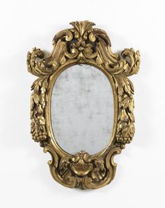MANIFATTURA DEL XVIII-XIX SECOLO - Specchiera in legno intagliato e dorato, con decorazioni a rilievo in forma di volute fitomorfe e ghirlande di frutti e foglie