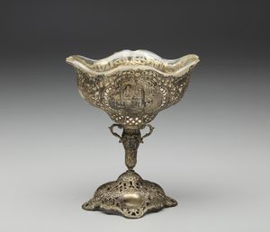 ARGENTIERE TEDESCO DEL XX SECOLO - Coppa in argento cesellato e traforato, con motivi decorativi fitomorfi a rilievo e decorazioni a tema biblico, vetro interno