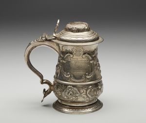 ARGENTIERE INGLESE DEL XIX SECOLO - Tankard in argento cesellato con motivi fitomorfi  in rilievo e dedica incisa sul corpo datata 1857