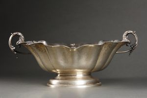 ARGENTIERE ITALIANO DEL XX SECOLO : Alzata centrotavola in argento con bordo mistilineo e decorazioni vegetali a rilievo, manici in forma di delfini, poggiante su base ovale  - Asta Asta 395 | ARTE ANTICA E DEL XIX SECOLO Online - Associazione Nazionale - Case d'Asta italiane