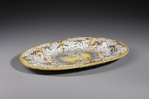 MANIFATTURA DI DERUTA : Piatto ovale in maiolica policroma decorato con putto alato armato di arco entro medaglione circolare contornato da decori a raffaellesche  - Asta Asta 395 | ARTE ANTICA E DEL XIX SECOLO Online - Associazione Nazionale - Case d'Asta italiane