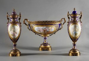 MANIFATTURA DI SEVRES DEL XIX-XX SECOLO - Trittico in porcellana e bronzo dorato composto da due anfore biansate decorate a scene galanti e da un'alzata a cratere biansata con scena galante di gusto settecentesco e interno decorato a rose
