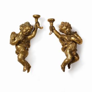 SCULTORE CENTROITALIANO DEL XVII-XVIII SECOLO - Coppia di putti alati in legno scolpito e dorato raffigurati nell'atto di reggere delle cornucopie