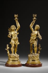RANCOULET ERNEST (1842 - 1918) - Da un modello di. Coppia di candelabri in bronzo dorato in forma di amorini alati reggifiaccola (allegorie di Autunno e Primavera)