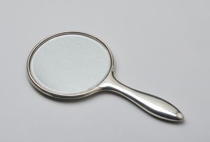 ARGENTIERE INGLESE DEL XIX-XX SECOLO - Specchio da toeletta  in argento con decorazioni a ghirlande incise al retro