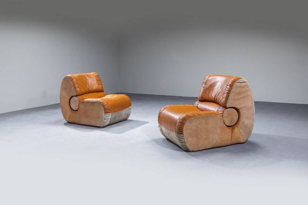 PRODUZIONE ITALIANA : Coppia di poltrone con imbottitura rivestita in pelle e camoscio. Anni '60 cm 78x67x100  Difetti  - Asta Design - Associazione Nazionale - Case d'Asta italiane