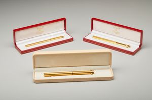CARTIER - Tre penne in metallo dorato di cui una penna stilo e due matite.