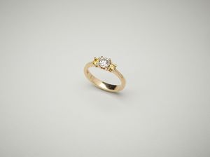 . - Anello in oro rosa 18 carati con diamante centrale di 0.60 ct. e due diamanti natural fancy yellow di 0.32 ct.