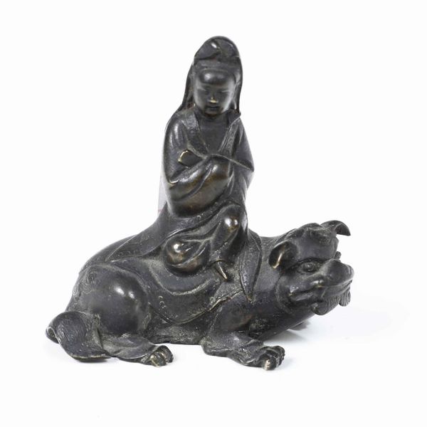 Figura di Guanyin seduta su cane di Pho in bronzo, Cina, XX secolo  - Asta Asian Art - Associazione Nazionale - Case d'Asta italiane
