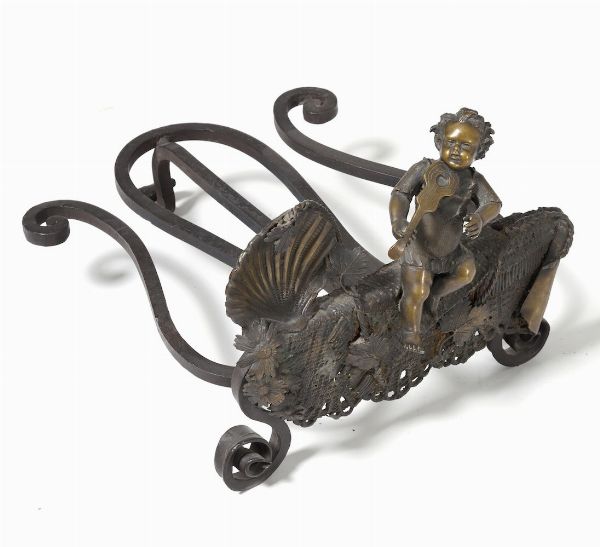 Alare da camino (?) in bronzo decorato con putto musicante e valva di conchiglia  - Asta Antiquariato Aprile - Associazione Nazionale - Case d'Asta italiane