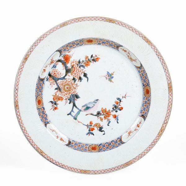Piatto in porcellana Imari con decori floreali e figura di uccellino tra i rami, Cina, Dinastia Qing, epoca Yongzheng (1723-1735)  - Asta Dimore italiane - Associazione Nazionale - Case d'Asta italiane