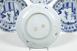 Quattro piatti in porcellana bianca e blu con personaggi e decori floreali, Cina, Dinastia Qing, epoca Kangxi (1662-1722)  - Asta Dimore italiane - Associazione Nazionale - Case d'Asta italiane
