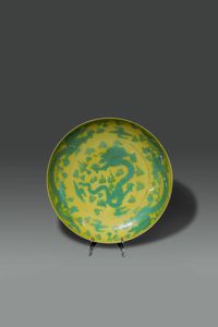 PIATTO - Piatto in porcellana a sfondo giallo dipinto con draghi tra le nuvole  Cina  dinastia Qing  XVIII sec Diam cm  [..]