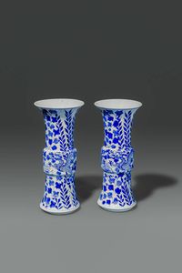 COPPIA DI VASI - Coppia di vasi a tromba in porcellana bianco e blu  dipinti con draghi e fiori  Cina  dinastia Qing  XVIII sec  [..]