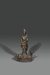 GUANYIN - Scultura in bronzo rappresentante Guanyin in posizione eretta  su pesce con lumeggiature in oro  Giappone  XX  [..]
