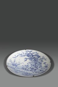 GRANDE PIATTO - Grande piatto da parata in porcellana bianca e blu decorato con uccelli e soggetti vegetali  Giappone  XIX Sec.  [..]