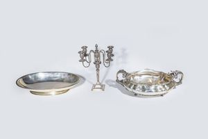 LOTTO DI  TRE OGGETTI IN ARGENTO - Peso gr 8290 1 composto da - 1 grande centrotavola di forma ovale sagomato e bombato con manici decorati a volute  [..]