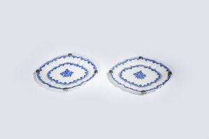 COPPIA DI PIATTINI - 27X23 di forma ovalizzata con bordo sagomato in porcellana bianca con decori blu. XVIII secolo. Presenti sbeccature  [..]