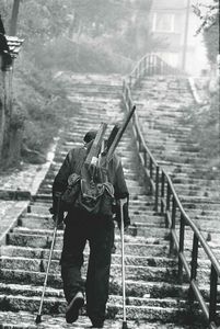 Attar Abbas : A man on crutches carries wood for fuel in his rucksack. Bosnie-Herzigovine, Sarajevo  - Asta Fotografia - Associazione Nazionale - Case d'Asta italiane