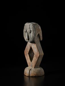 Kota - Gabon - Scultura antropomorfa stilizzata in forma di guardiano di reliquiario Mbulu ngulu. Legno e lega di rame, ferro e resine.