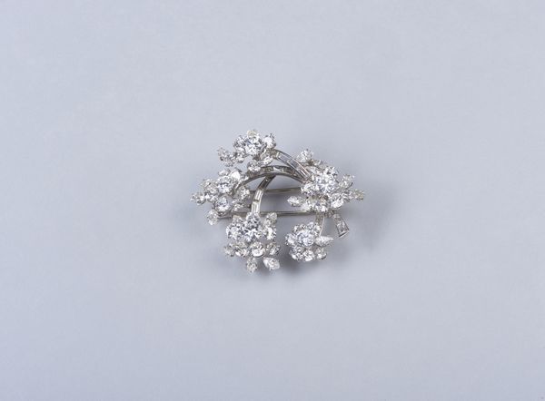 . : Spilla in platino con motivi floreali e diamanti bianchi taglio a brillante, navette e baguette. Peso totale stimato 13,00  ct. ca.  - Asta GIOIELLI - OROLOGI - ALL I WANT FOR CHRISTMAS Online - Associazione Nazionale - Case d'Asta italiane