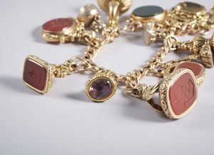 . - Raro e squisito bracciale con n. 13 sigilli e catena per allungo a collana in oro basso titolo.