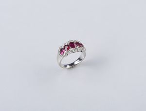 . - Anello a fascia in oro bianco 18k con rubini da 1,09 ct. ca. e diamanti taglio a brillante dal peso stimato di 0,60 ct.