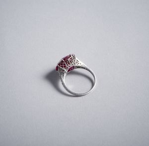 TIFFANY : Notevole e delizioso anello Tiffany in oro bianco 18k con rubino centrale taglio cuscino di 9,35ct. ca. Con contorno di 14 diamanti taglio huit-huit. Anni 40.  - Asta GIOIELLI - OROLOGI - ALL I WANT FOR CHRISTMAS Online - Associazione Nazionale - Case d'Asta italiane