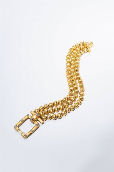 BRACCIALE : Peso gr 55 1 Lunghezza cm 17 in oro giallo  composto da tre fili di sfere satinate. Chiusura di forma rettangolare con stelle in oro bianco e diamantini taglio 8/8.  - Asta Gioielli - Associazione Nazionale - Case d'Asta italiane