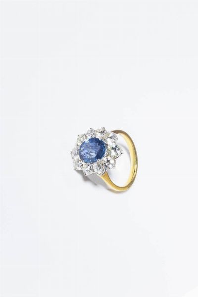 ANELLO : Peso gr 6 5 Misura 14 (54) in oro bianco e giallo  sommit a margherita con al centro zaffiro taglio ovale di ct 3 50 ca  contornato da diamanti taglio brillante per totali ct 2 30 ca  probabile colore G-H  purezza IF-VVS.  - Asta Gioielli - Associazione Nazionale - Case d'Asta italiane
