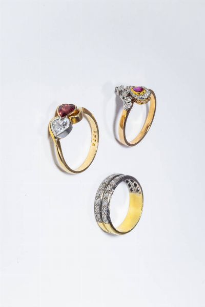 LOTTO DI TRE ANELLI : -in oro giallo e bianco a bassa caratura con due file di zirconi. Peso gr 4 7. Misura 14 (54) -in oro giallo con due gemme sintetiche. Peso gr 2 9. Misura 16 (56) -in oro giallo e bianco  con rubino taglio a goccia e rosette per totali ct 0 15 (una mancante). Peso gr 3. Misura 17 (57)  - Asta Gioielli - Associazione Nazionale - Case d'Asta italiane